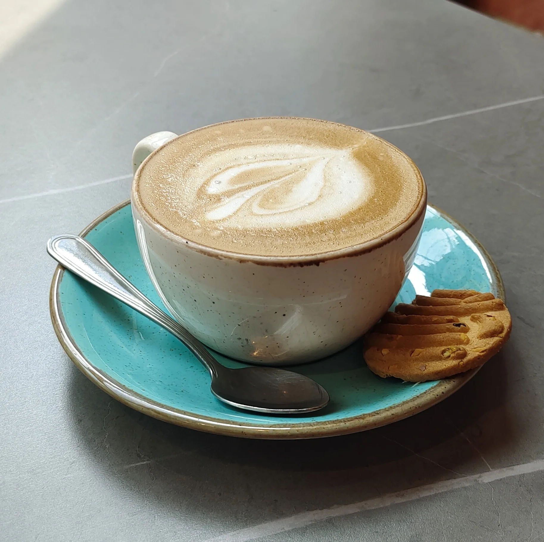 Cappuccino photo taken under harsh overhead cafe lighting